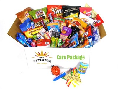 Open box with text: The Ultimate Care Package and Care package. Chips, snacks, and candy bags fill the box with toys in front of the box.
