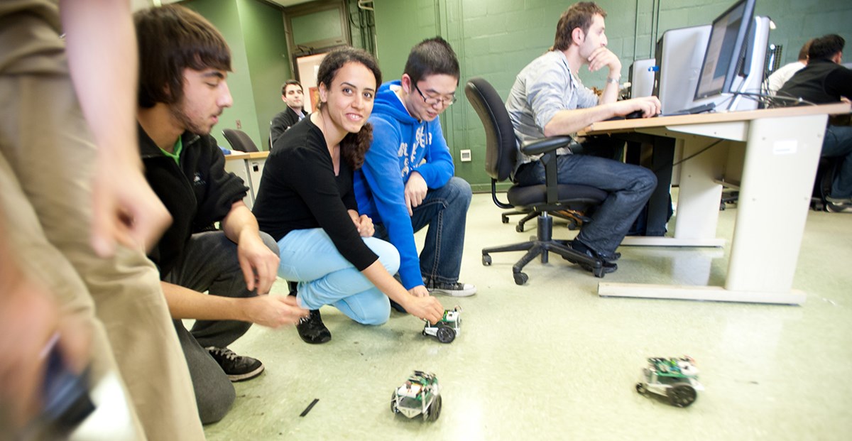 Electrical and Computer Engineering students showing off robots they built