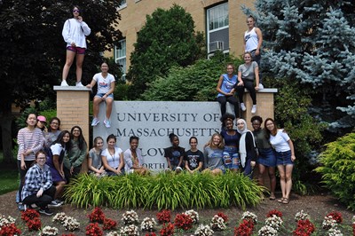 This is the group of twenty one young women who joined the RAMP program in summer of 2018, posing in front of and top of the large Univ. of Massachusetts Lowell sign on university ave. they look happy and eager to get started. 