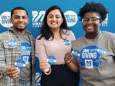 Three students hold Days of Giving buttons