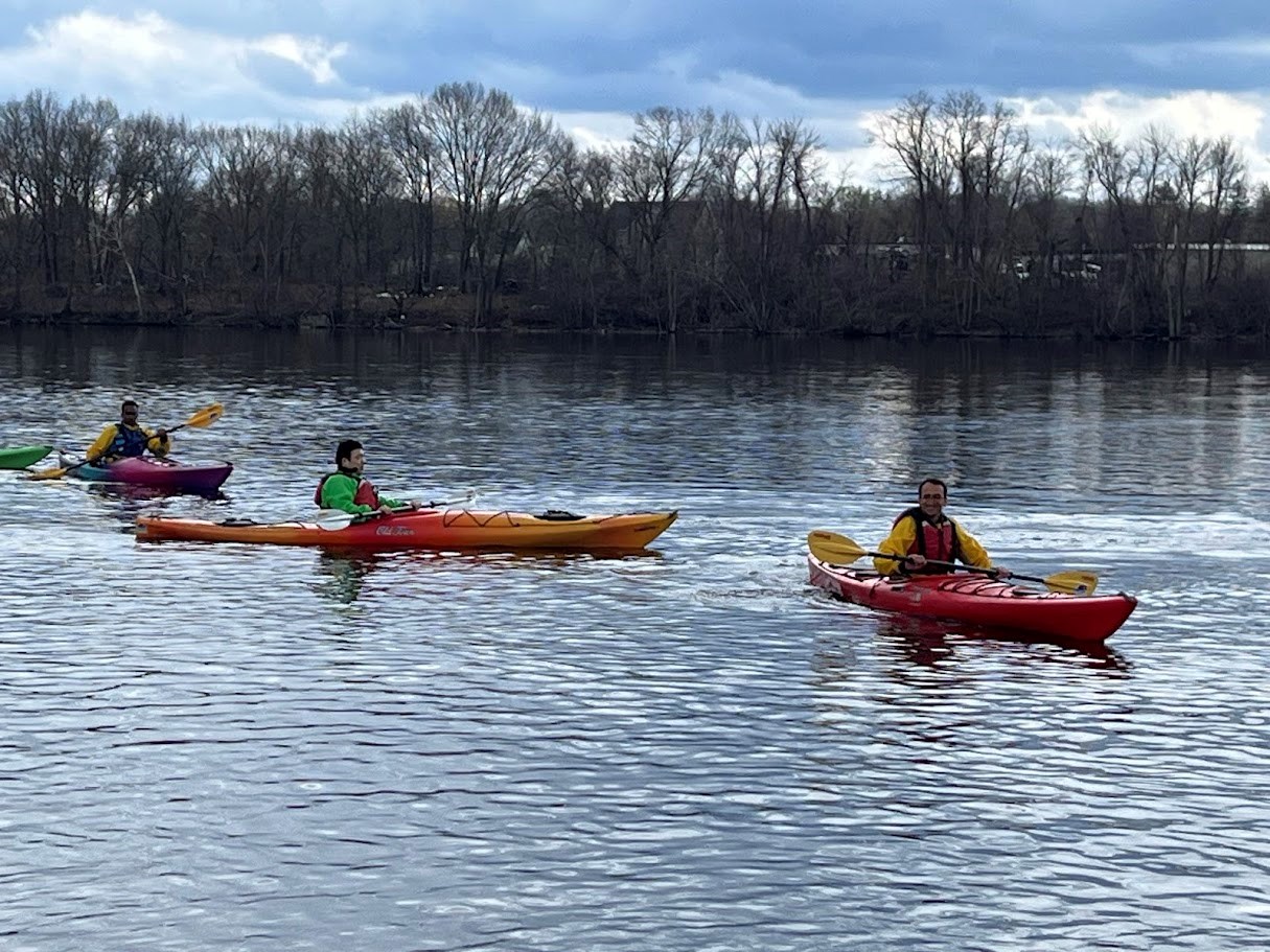 3 kayakers float on the river