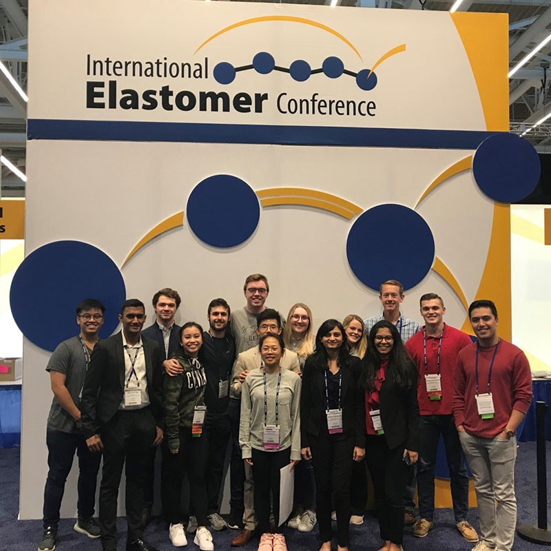 Group of students in front of International Elastomer Conference sign