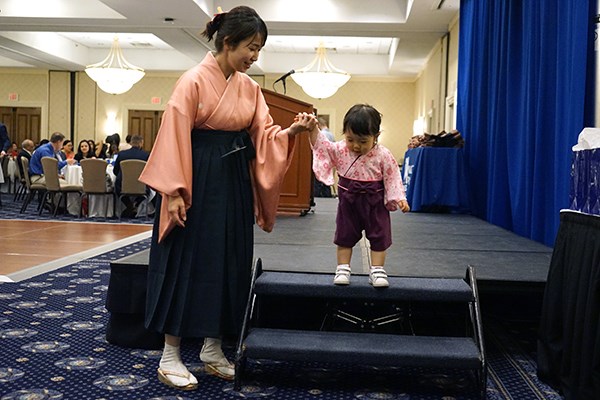 An Abitus grad helps her child step off the stage