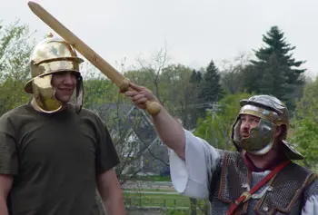 History student Evan Giannakas helps Neal Bourbeau, educational programs manager at Higgins Armory Museum, demonstrate the efficiency of ancient Roman helmets at a recent demonstration at UMass Lowell.