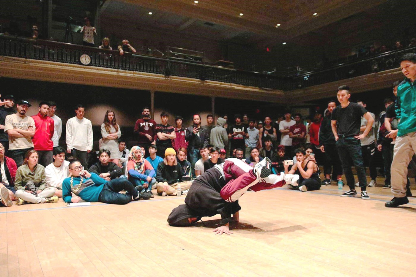 UML student breakdancing on stage with teammates
