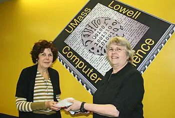 Computer science teacher Jeanne Kendall of Lowell High School, right, receives Finch robots from Phyllis Procter, manager of UMass Lowell&rsquo;s Community Partnership Program.