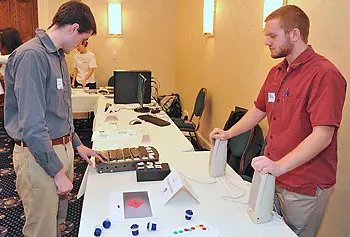 William Gould, right, demonstrates the Speech Assistant, a device intended for use by children with autism or other developmental disabilities, during the Campus Catalyst Showcase in December.