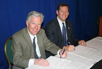 UMass Lowell Chancellor Marty Meehan, left, and Middlesex County District Attorney Gerard Leone sign a partnership agreement for research and intervention programs.