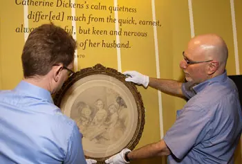 Florian Schweizer, left, and David Blackburn installed the long-awaited portrait of Charles Dickens's young children for the "Dickens in Massachusetts" exhibit running through October.