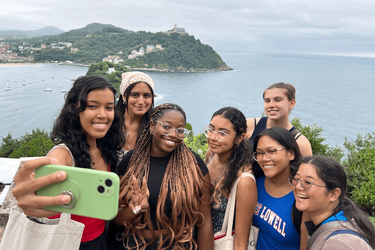 a group of seven college students take a selfie overlooking a body of water