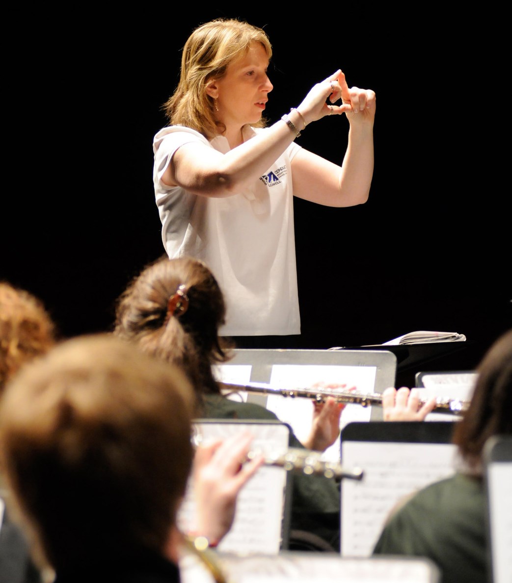 Conductor Deb Huber of the University of Massachusetts Lowell explains a musical phrase to her concert band ensemble.