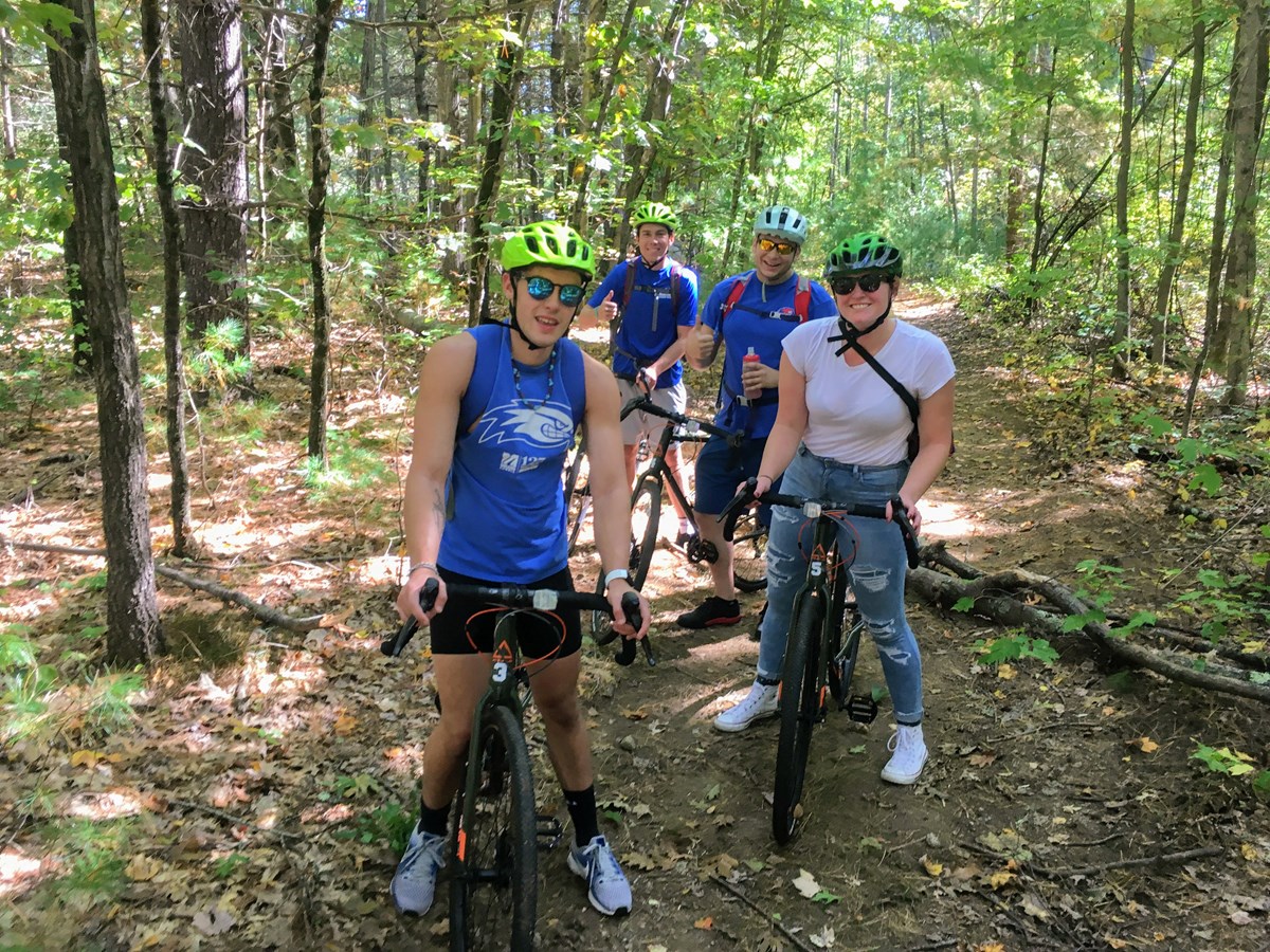 Four cyclists posing with their bikes in the forest