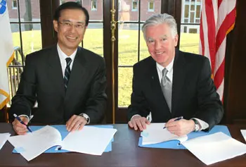 Toyoaki Miwa, president of executive education firm Abitus, signs an agreement with Chancellor Marty Meehan for UMass Lowell to offer its MBA program in Japan.