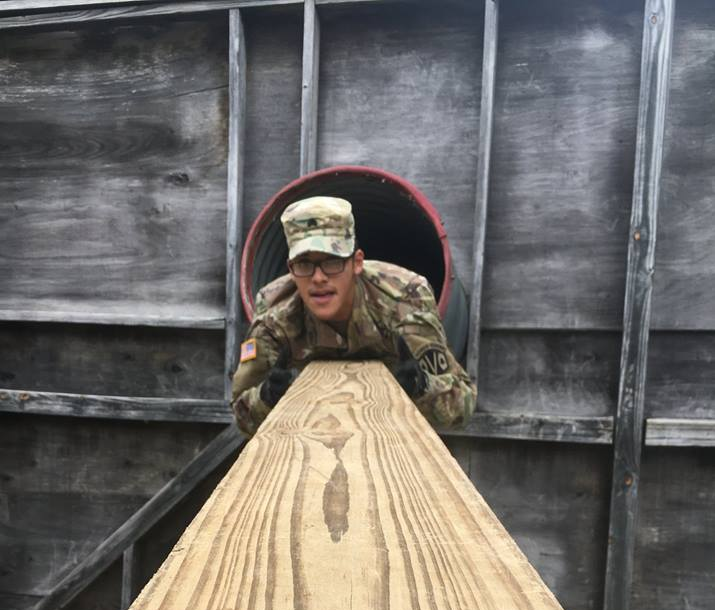 Cadet looking down a plank of wood from a metal tube