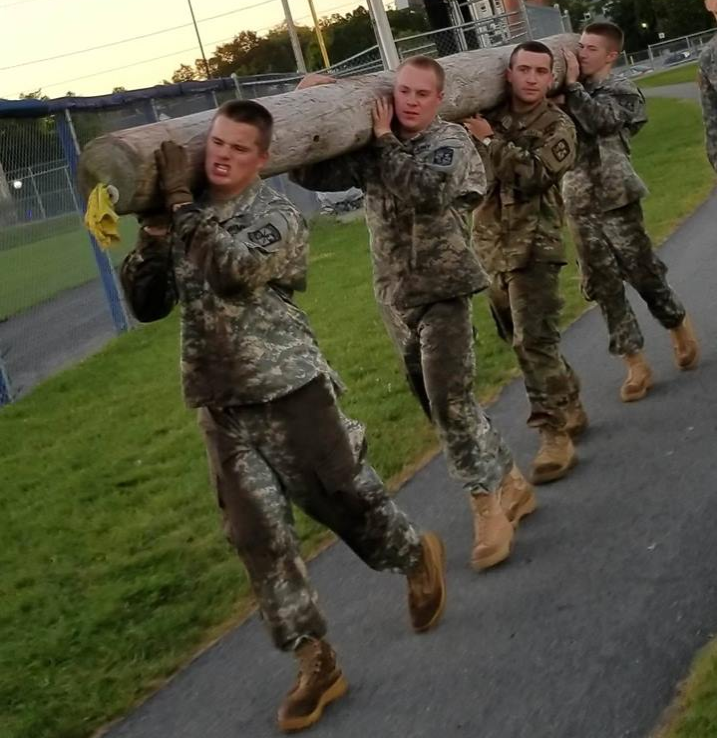 Four Cadets carrying a log