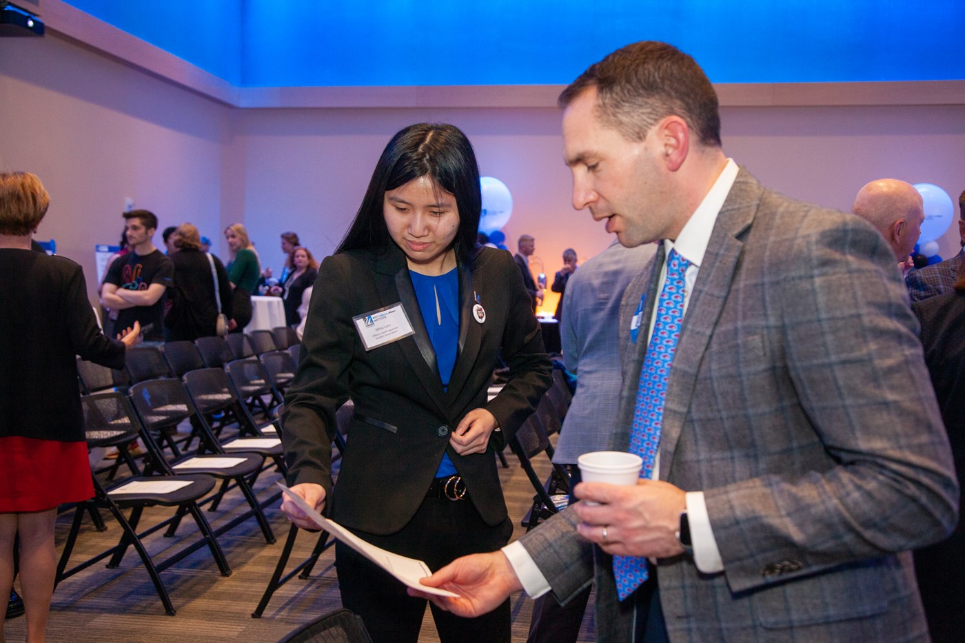 Mina Lam and Derek Berger looking at the event schedule at the 2022 DifferenceMaker Idea Challenge