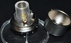The nanocanary sensor uses a quartz crystal (thin disk mounted on the metal base) to detect changes in the health of cells living in a solution of nutrients above the crystal (clear cylinder attached to the quartz).