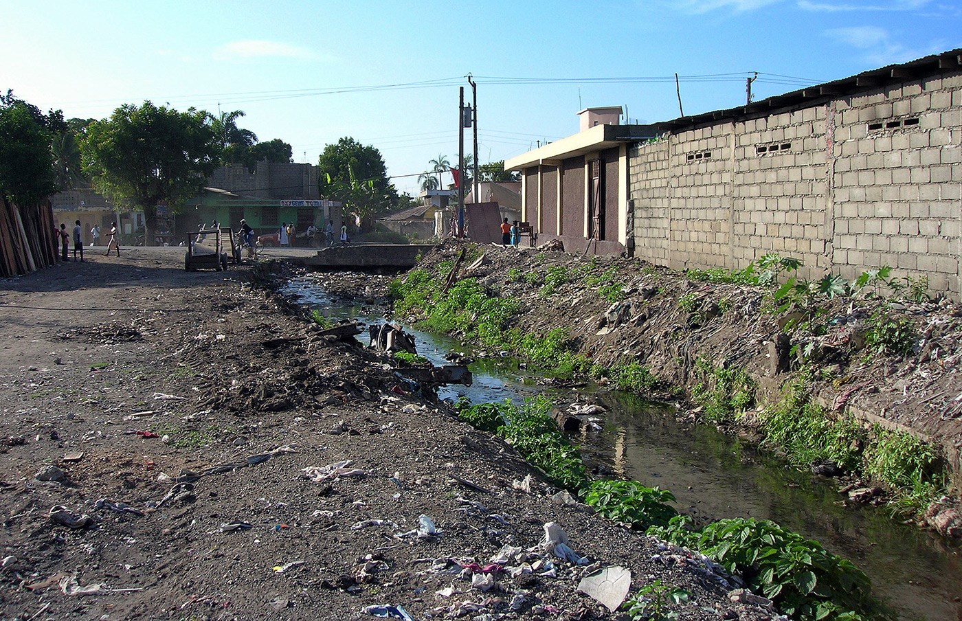  Poor sanitation in the area of Dlo Gervier, Cap-Haitien, Haiti : solid waste on the ground, drainage channel blocked, plastic bags containing excreta, road damaged by runoff water.