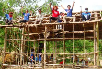 Volunteers celebrate completing the framework, as they build new houses for poor families in rural Cambodia. Directed by student Tola N. Sok, Project Save One Khmer built six houses in nine days.
