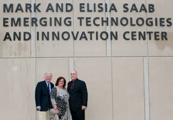 Chancellor Marty Meehan, left, stands with Elisia and Mark Saab below the newly unveiled name of the university's $80 million academic building.