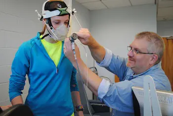 Sean Collins attaches a mass flow sensor that measures oxygen intake.