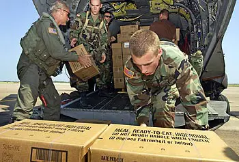 U.S. Army soldiers load boxes of Meals, Ready to Eat (MREs) onto a CH-47 Chinook helicopter.