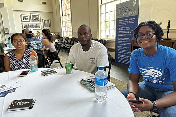 Oliver Ochije, a criminal justice major, at a table with his peer ally and transfer students Shreya Kumar and Kirsten Ingram at the TAP welcome event