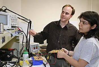 Assoc. Prof. Joel Therrien works with a student in the lab.