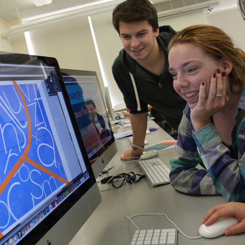 Two students at a computer in a UMass Lowell art classroom