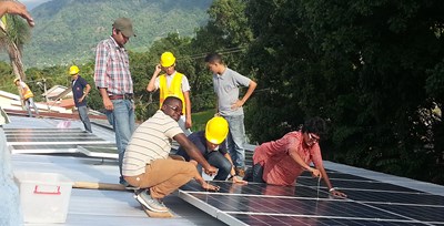 UMass Lowell students and Loyola Electrical Students installing PV modules on a roof in a developing country.