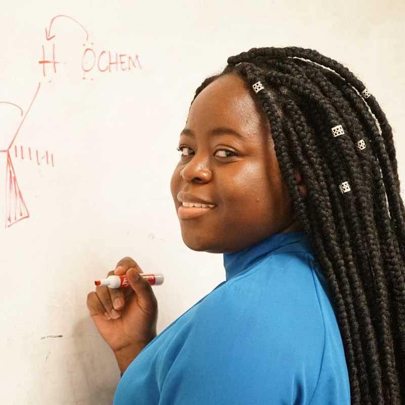 Biology student writes a formula on a whiteboard