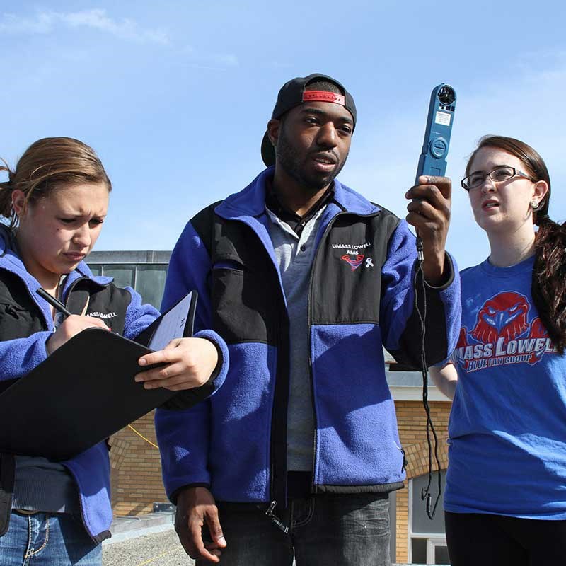 Three UMass Lowell students take weather readings with equipment