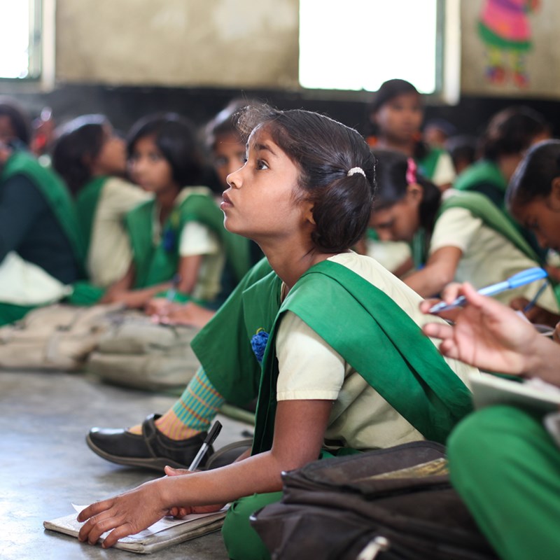 A young girl attentively listens at a free school for girls in the town of Anupshahr called Pardada Pardadi