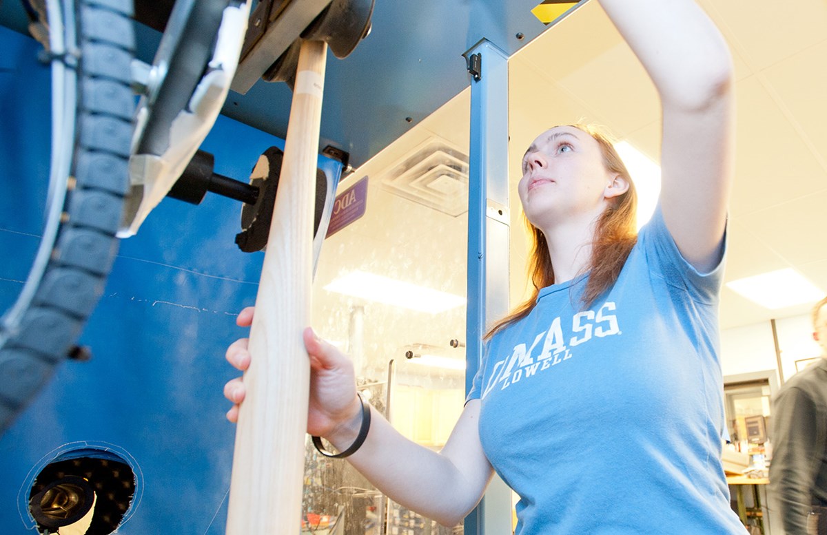A female student works with a baseball bat in the Mechanical Engineering bat lab.