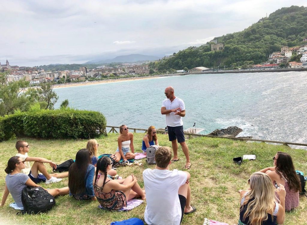 Professor talks to students on banks of lake in Spain