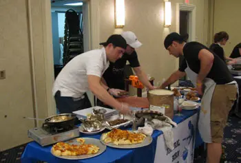 Graduate students Thomas Sniezek, Timothy Duffy and Jason Skeldon put the finishing touches on their winning meal in the third annual campus Iron Chef competition.