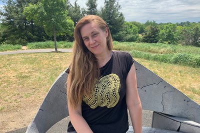 Kirsten Swenson, seated on a "throne" of recycled aluminum at the top of Mierle Laderman Ukeles's public earthwork, "Turnaround/Surround," at Danehy Park in Cambridge. 
