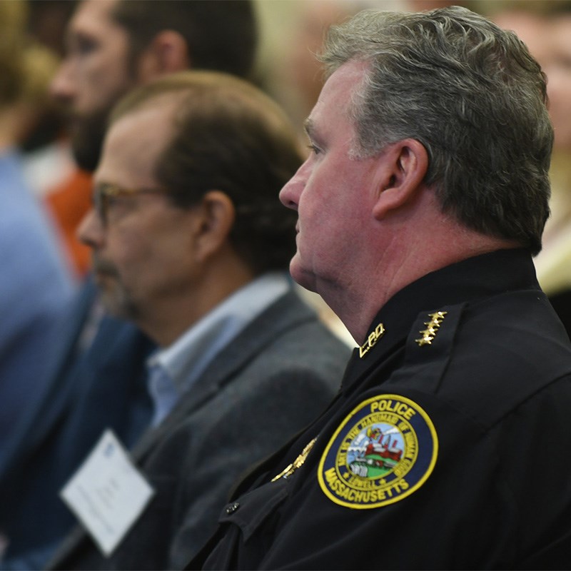 Police officer listening to presentation while seated in audience
