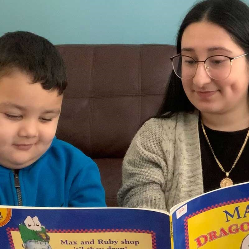 UMass Lowell student Nery Rodriguez reads with a child