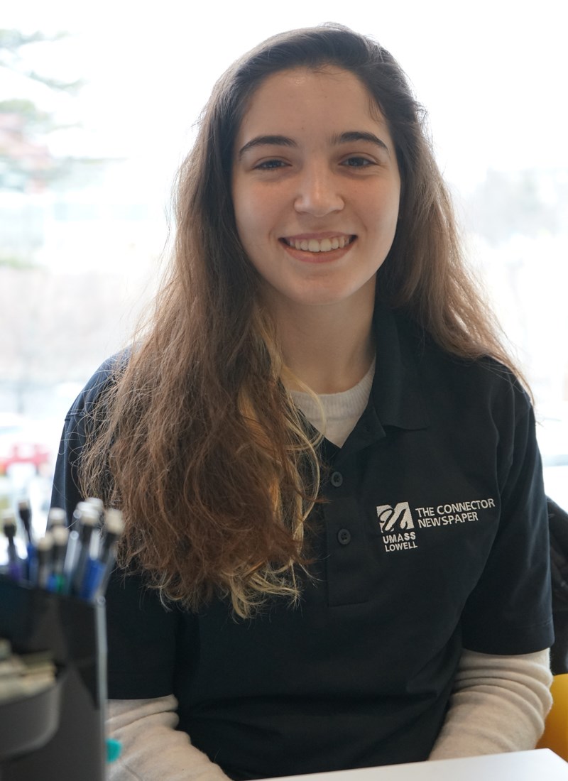 Taylor Carito, editor-in-chief of UMass Lowell's student newspaper, the Connector, smiles in The Connector office