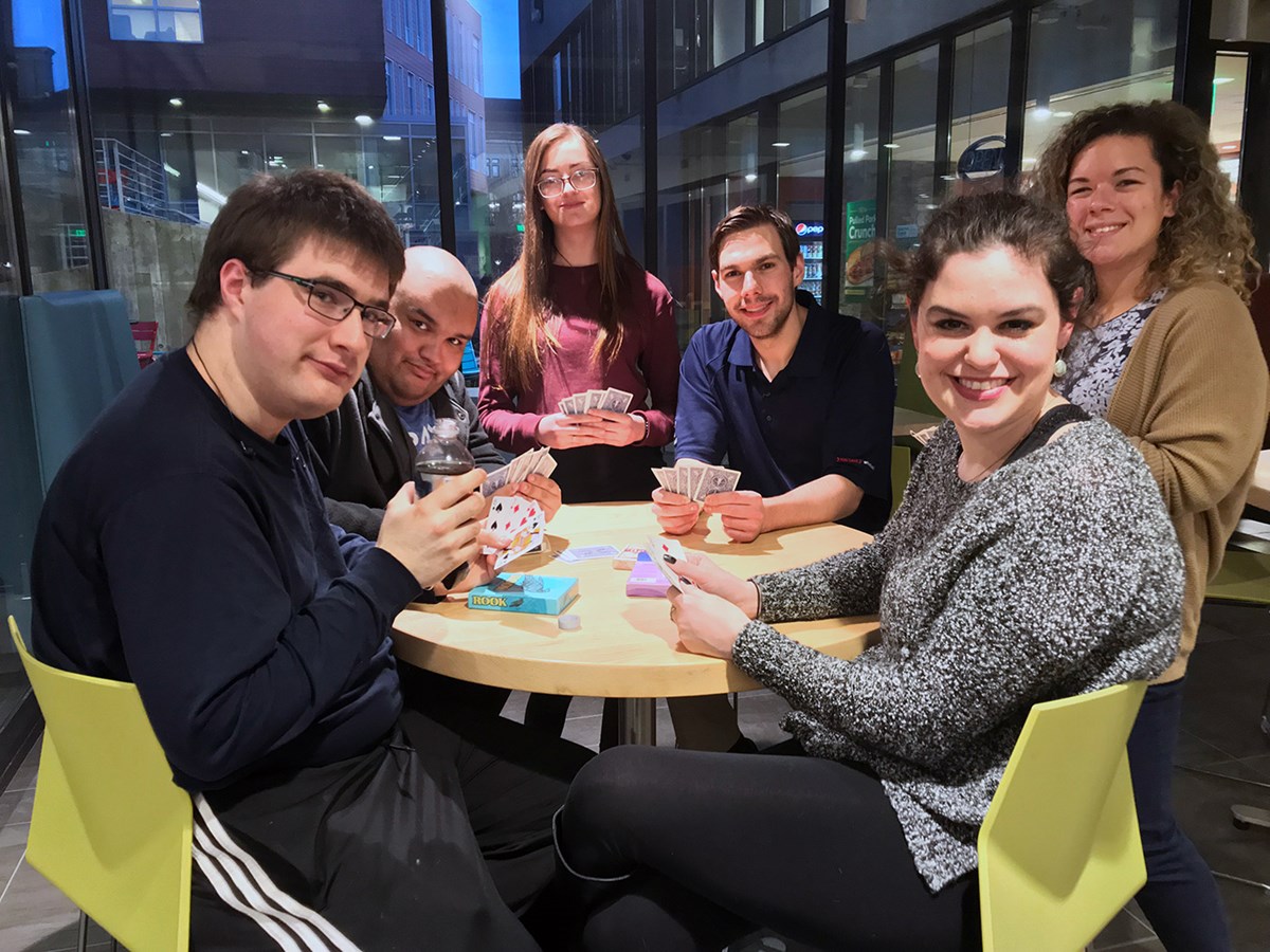Group photo of "The Network" showing young men and women sitting around a table playing cards. The Network is a monthly social networking program for high functioning adolescents and young adults on the autism spectrum aged between 16-30 years. The goal is to provide those with ASD an opportunity to meet others and hopefully make connections.