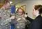 Maj. Joel Dillon and Deana Archambault of the U.S. Army’s Natick Labs assist U.S. Rep. Niki Tsongas in trying on a lightweight body armor designed for women during the Feb. 7 launch of the HEROES initiative at UMass Lowell.