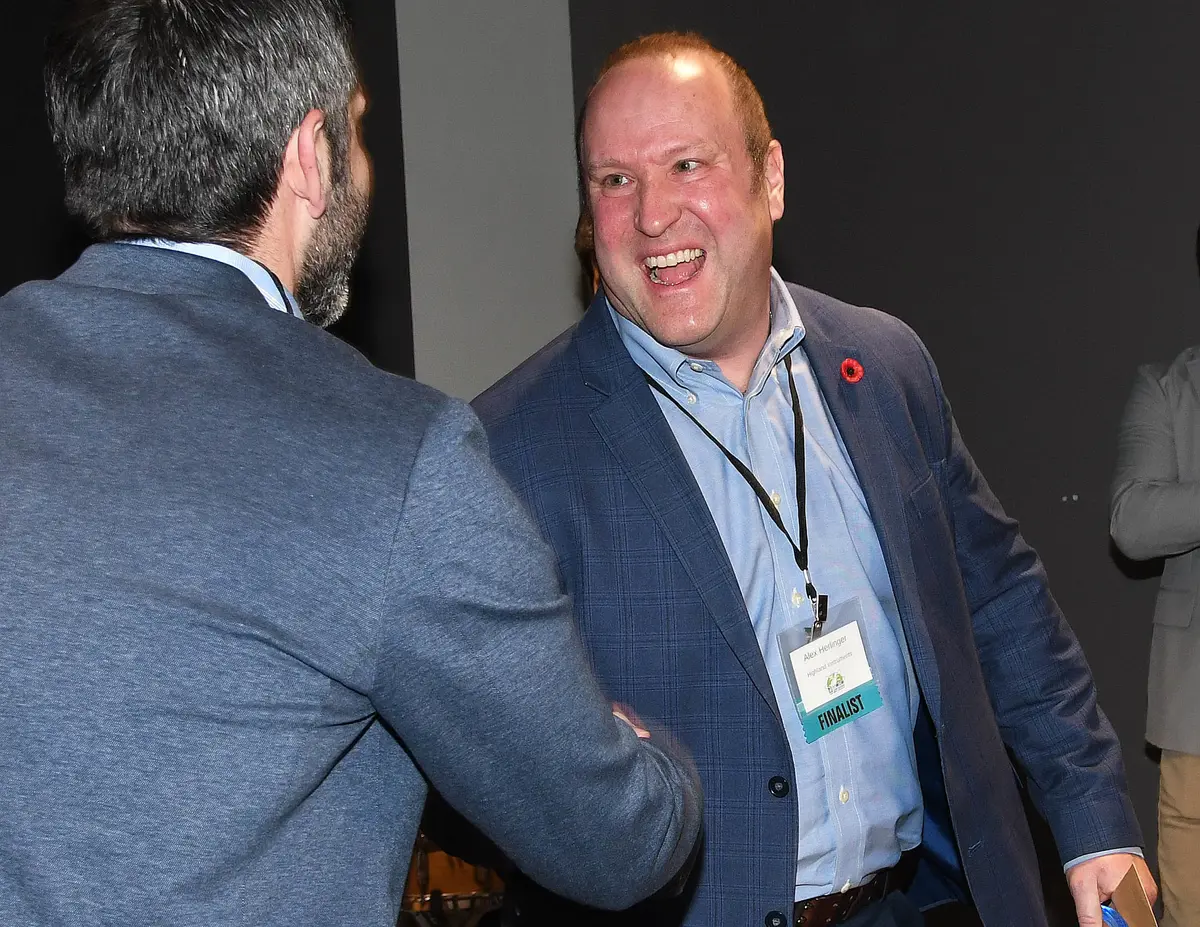 Alex Herzlinger shakes someone's hand.