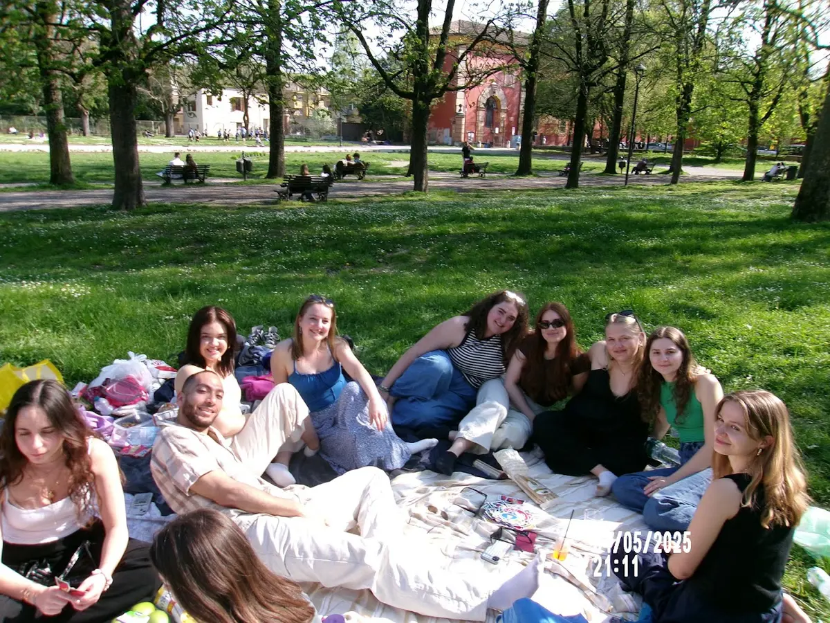 Celia Schoenfeld seated on the grass of the Giardino Estense with fellow international students during a picnic.