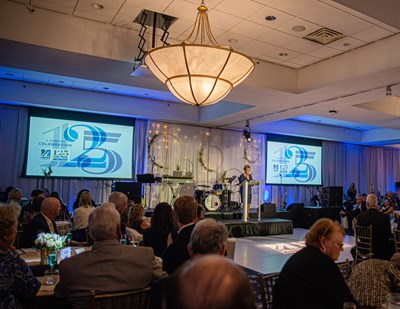 Chancellor Jacquie Moloney speaks in front of a large crowd at UMass Lowell's 125th Anniversary Celebration gala