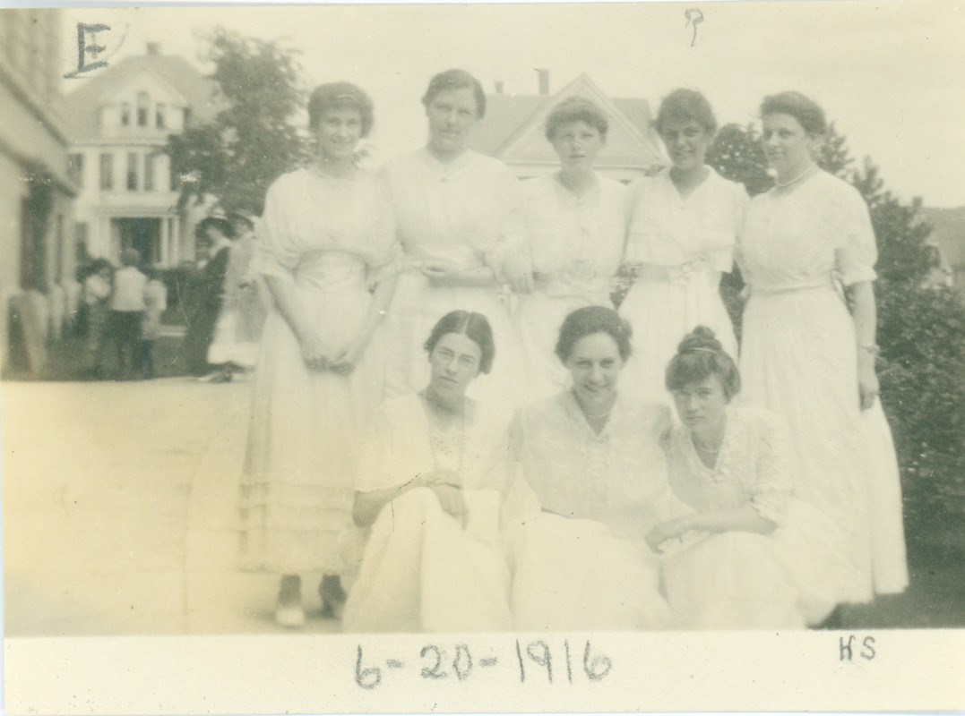 Female graduates wearing white dresses in 1916 that were traditional for the time