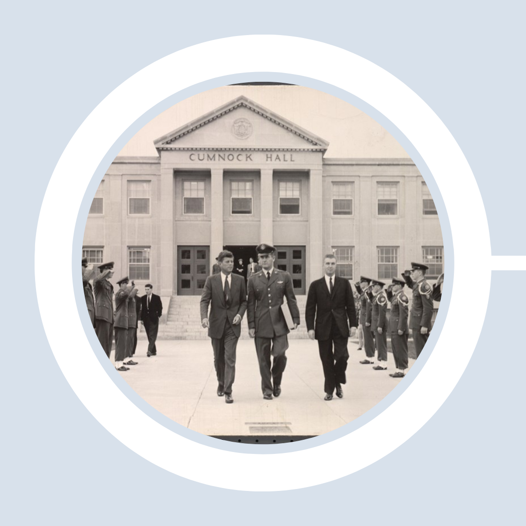 John F. Kennedy exits Cumnock Hall through an aisle of regimented soldiers in formation.