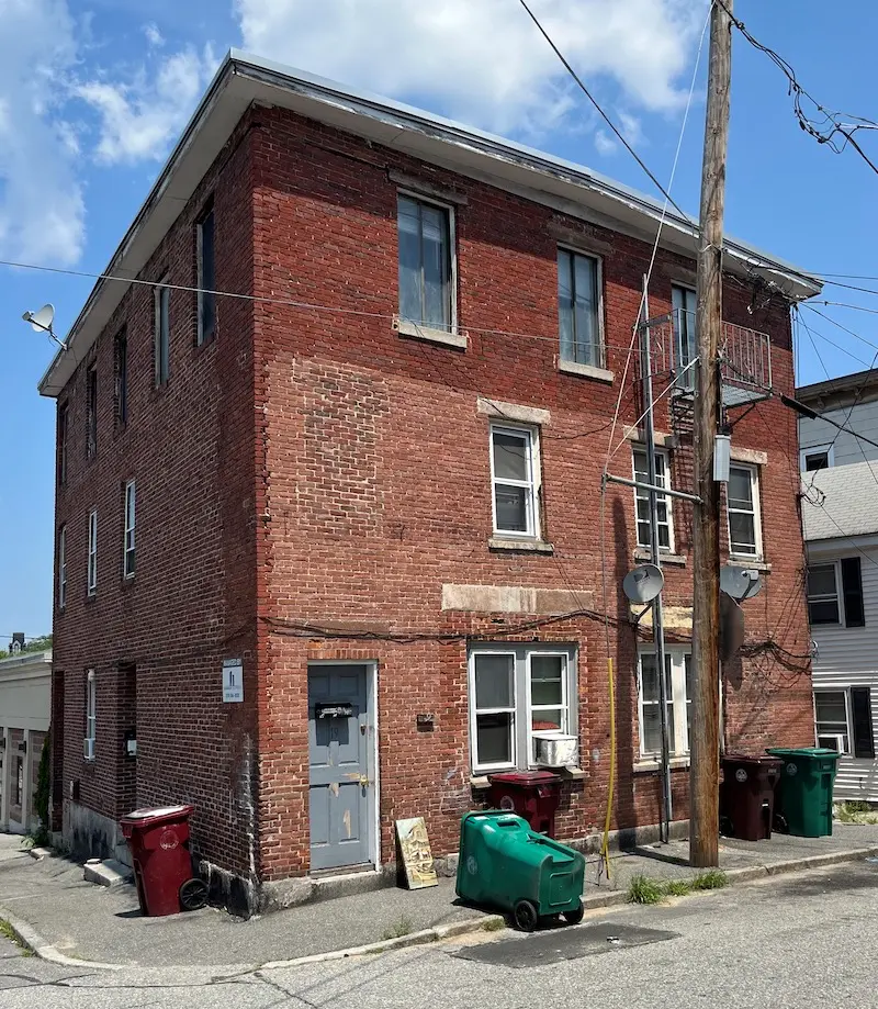 Three story brick building in Federal style.