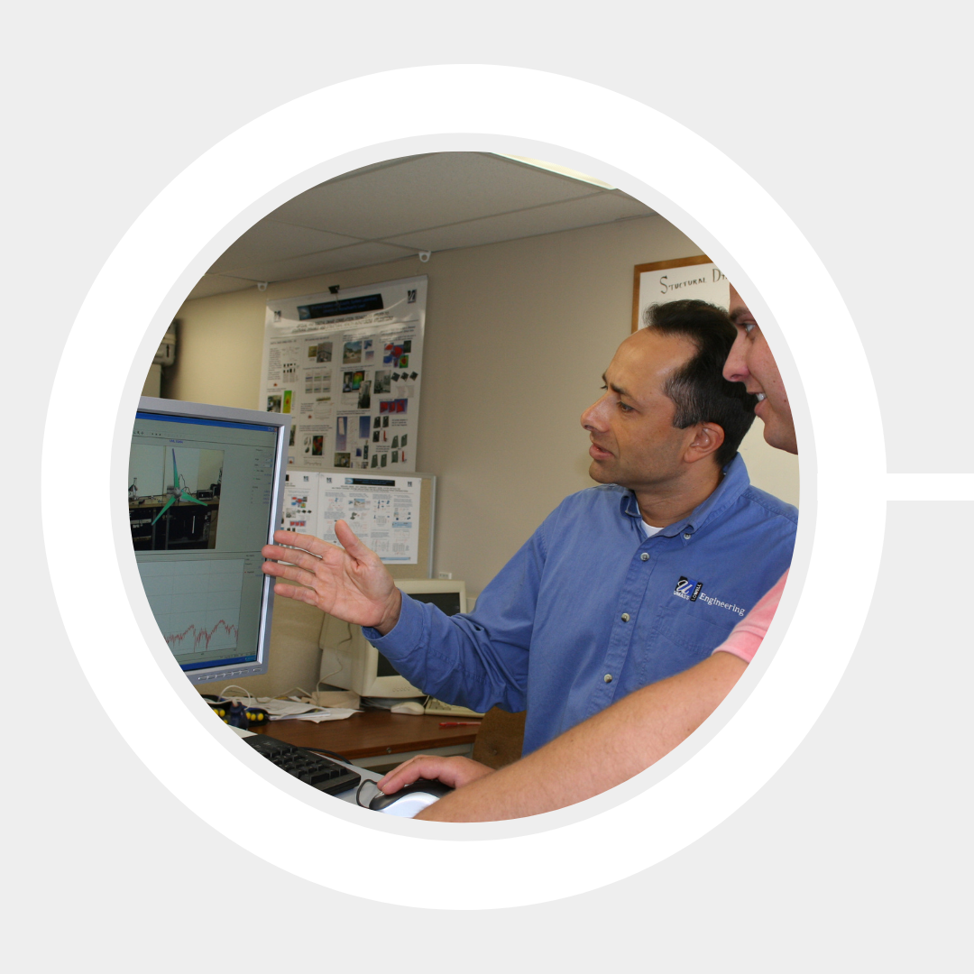 Prof. Christopher Niezrecki demonstrates wind turbine monitoring software to a student.