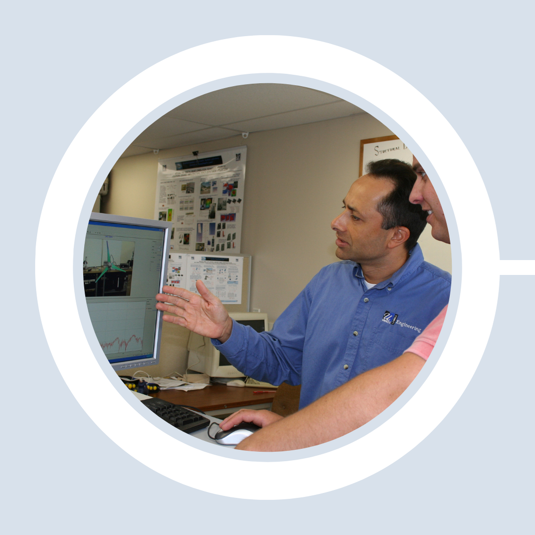 Prof. Christopher Niezrecki demonstrates wind turbine monitoring software to a student.